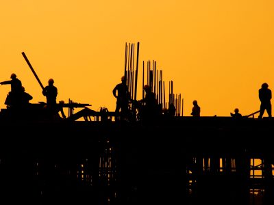Construction workers at sunset.